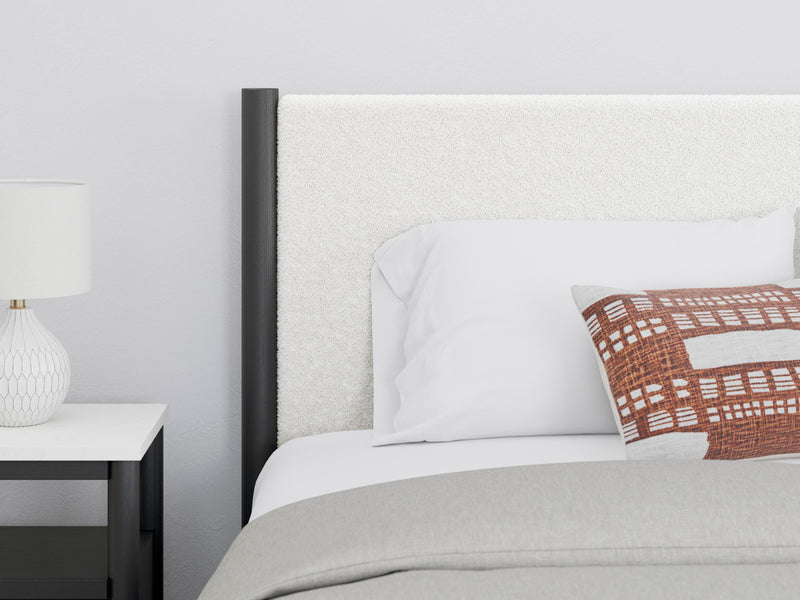 Close-up of Ashley Furniture Cadmori upholstered bed frame with detailed fabric and tufted headboard.