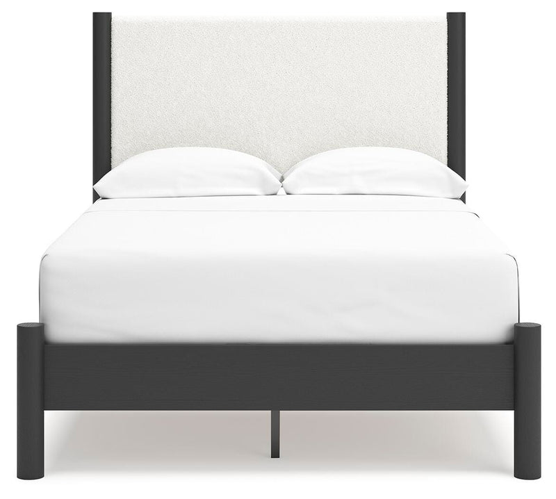 Ashley Furniture Cadmori upholstered bed with a padded headboard and neutral fabric, shown from a front head-on view.