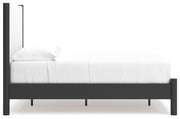 Ashley Furniture Cadmori upholstered bed with plush headboard and neutral fabric, shown in a stylish bedroom setting.