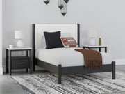 Ashley Furniture Cadmori upholstered bed with a padded headboard and neutral fabric, showcased in a stylish bedroom setting.