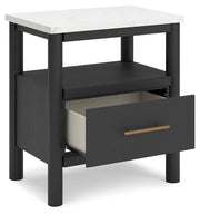 Ashley Furniture Cadmori bedroom set with a bed, dresser, and nightstands shown from an angled view in a modern bedroom setting.