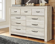 Ashley Furniture Bellaby Dresser featuring multiple drawers in a modern wooden finish, shown in a close-up image.