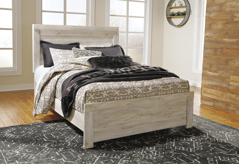 Ashley Furniture Bellaby Bed in a stylish design with a wooden frame and headboard, shown in a cozy bedroom setting.