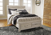 Ashley Furniture Bellaby bedroom set with a sleek bed frame, matching nightstands, and dresser in a modern bedroom display.