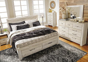 Ashley Furniture Bellaby bed with two storage drawers, featuring a wooden frame and modern design, shown in a cozy bedroom setting.