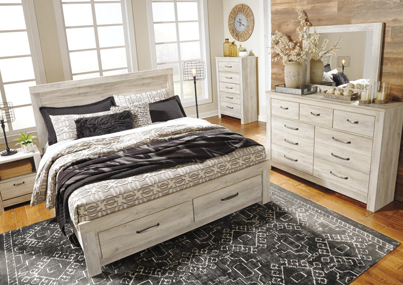 Ashley Furniture Bellaby bed with two storage drawers, featuring a wooden frame and modern design, shown in a cozy bedroom setting.