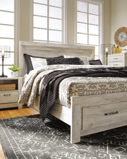 Ashley Furniture Bellaby bed with two storage drawers, showcasing a modern wooden bed frame with integrated storage in a cozy bedroom setting.