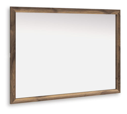 Ashley Furniture Chirason bedroom mirror with a sleek, framed design, shown at an angle on a modern bedroom wall.