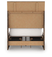 Ashley Furniture Chirason Bed with a dark wood finish and elegant headboard, shown from the back in a well-lit bedroom setting.