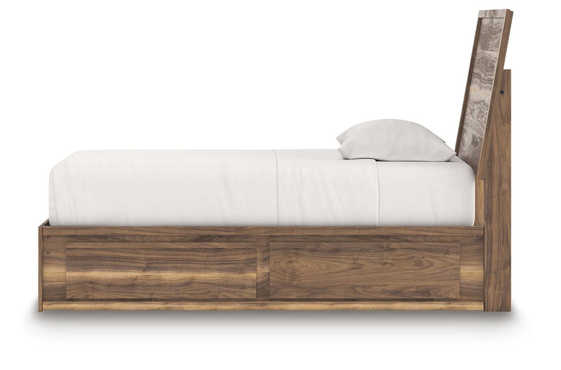 Ashley Furniture Chirason Bed with wooden frame and headboard, shown in a cozy bedroom setting.