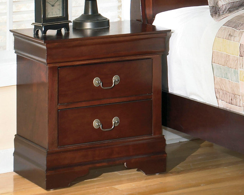 Ashley Furniture Alisdair Nightstand with wood finish and storage drawer, shown in a well-lit bedroom setting.