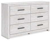 Ashley Furniture Cayboni dresser with multiple drawers, shown from an angled side view in a modern bedroom setting.