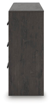 Ashley Furniture Prendonea dresser with multiple drawers and a sleek wood finish, styled for modern bedroom decor.
