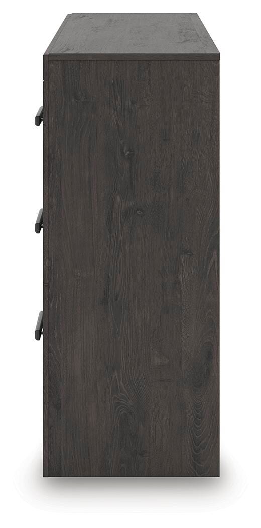 Ashley Furniture Prendonea dresser with multiple drawers and a sleek wood finish, styled for modern bedroom decor.
