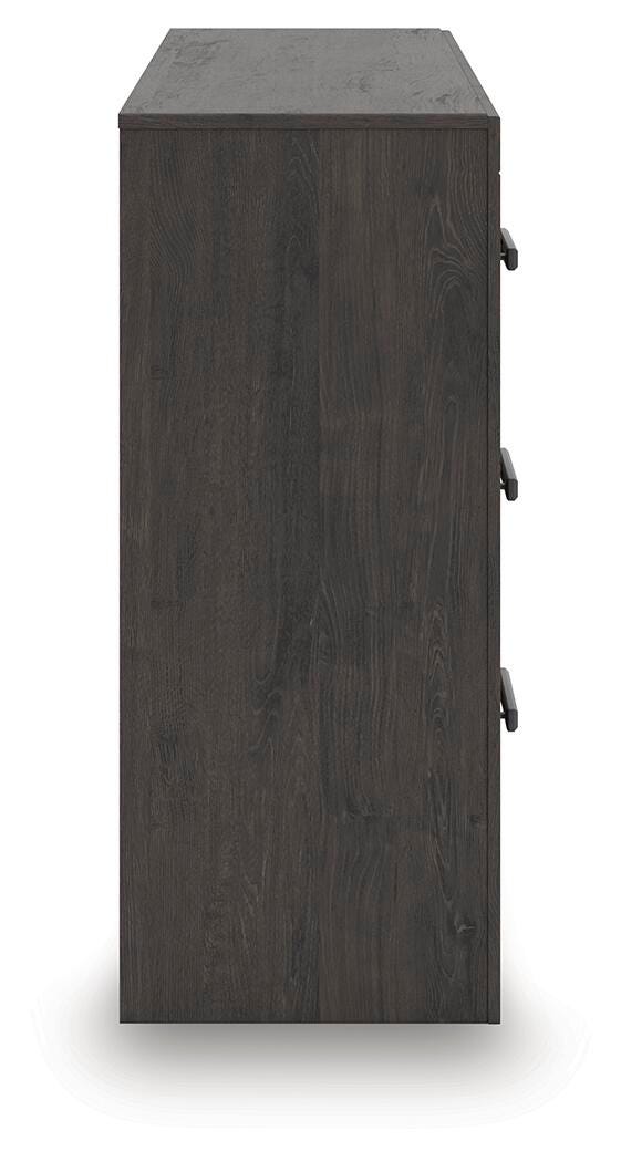 Ashley Furniture Prendonea dresser with sleek wood finish and multiple drawers, shown from a side view.
