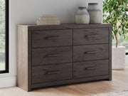 Ashley Furniture Prendonea Dresser with multiple drawers and sleek wood finish, showcasing a modern bedroom storage solution.