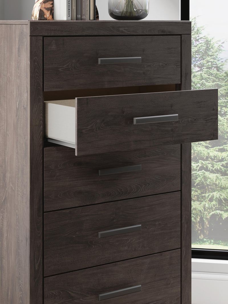 Ashley Furniture Prendonea chest of drawers with detailed wood finish and multiple drawers in a classic bedroom setting.