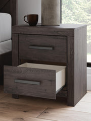 Close-up of Ashley Furniture Prendonea Nightstand with dark wood finish and detailed hardware.