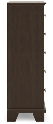 Ashley Furniture Covetown chest of drawers with multiple drawers and wooden finish, shown from a side angle.