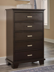 Ashley Furniture Covetown Chest of Drawers with four drawers and a dark wood finish, showcasing a sleek, modern bedroom storage piece.