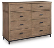 Ashley Furniture Tomtyn Dresser with multiple drawers, shown from an angled view in a stylish bedroom setting.