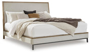 Ashley Furniture Tomtyn upholstered bed with a padded headboard and neutral fabric, shown in a modern bedroom setting.