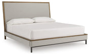 Ashley Furniture Tomtyn upholstered bed with a stylish headboard and neutral fabric, shown from a side angle.