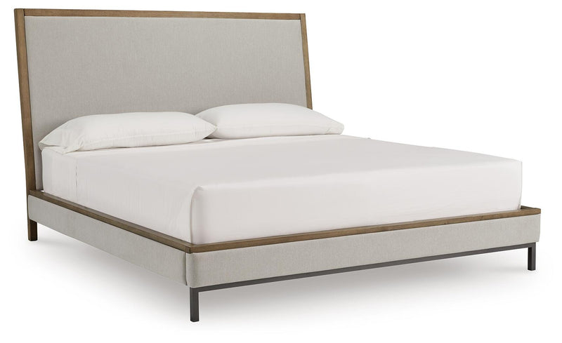 Ashley Furniture Tomtyn upholstered bed with a stylish headboard and neutral fabric, shown from a side angle.