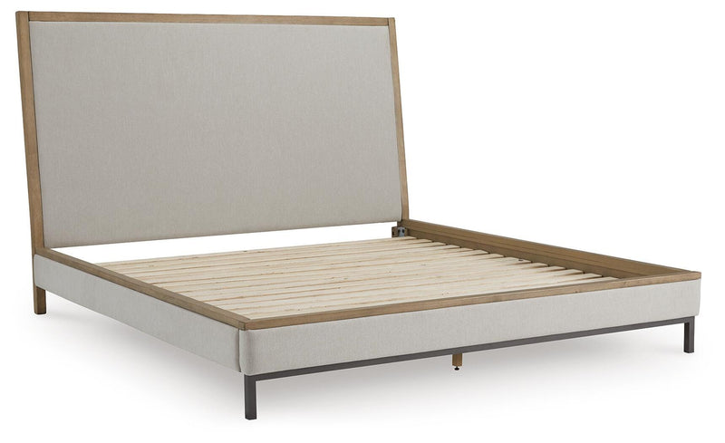 Ashley Furniture Tomtyn upholstered bed with padded headboard and sleek design, shown from a stylish angled view.