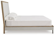 Ashley Furniture Tomtyn upholstered bed with a padded headboard and dark wood finish, shown in a side view.