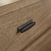 Close-up of Ashley Furniture Tomtyn Dresser showing detailed handle design and wood finish.