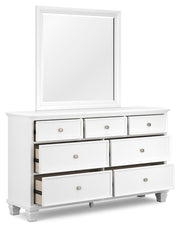 Ashley Furniture Fortman dresser and mirror set, showing a wooden dresser with mirrored top and storage drawers from a side angle.