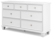 Ashley Furniture Fortman dresser with multiple drawers and sleek wood finish, shown from an angled side view.
