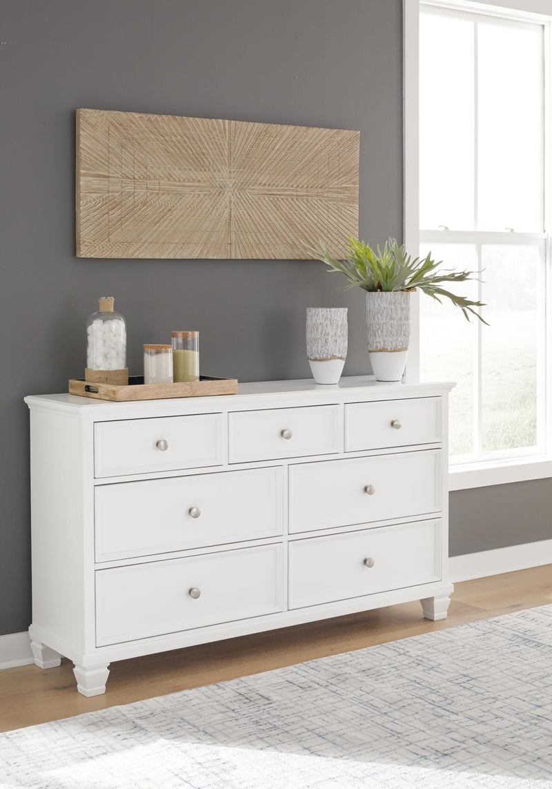 Ashley Furniture Fortman dresser with multiple drawers and a dark wood finish, showcasing a modern bedroom storage solution.