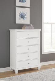 Ashley Furniture Fortman chest of drawers with a sleek wooden finish and multiple storage drawers.