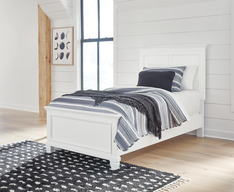 Ashley Furniture Fortman Bed with upholstered headboard and wooden frame, shown in a spacious bedroom setting.