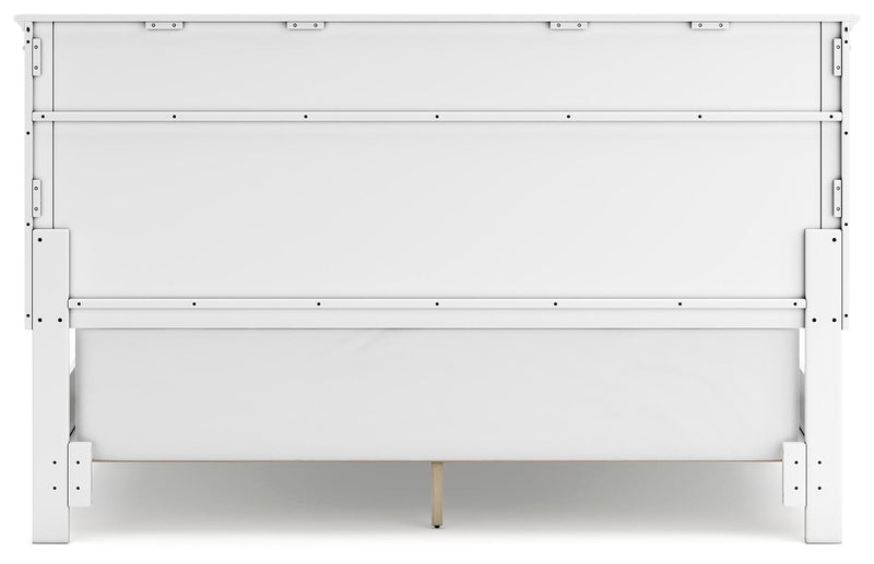 Ashley Furniture Fortman bed with a sturdy wooden frame and classic design, shown from the back in a well-lit bedroom setting.