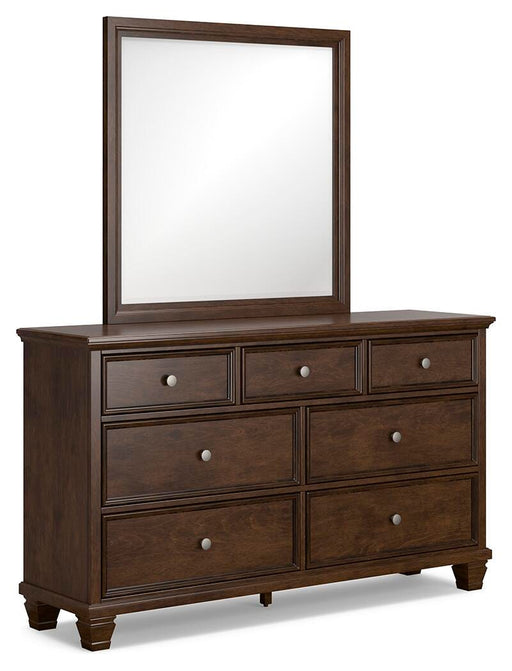 Ashley Furniture Danabrin dresser with attached mirror, showcasing a modern wood finish and sleek hardware in a well-lit bedroom setting.