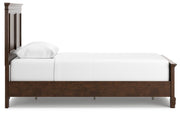 Ashley Furniture Danabrin Bed with side view, showcasing the wooden frame and detailed headboard design.