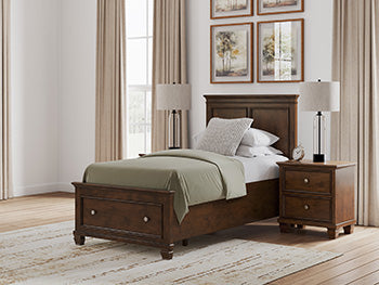 Ashley Furniture Danabrin panel storage bed with built-in storage drawers and modern wood finish, shown in a contemporary bedroom setting.