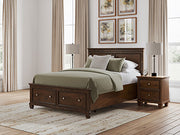 Ashley Furniture Danabrin panel storage bed with a sleek frame and built-in storage drawers, showcasing a modern bedroom centerpiece.