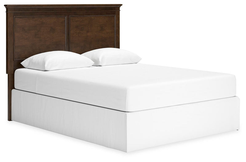 Ashley Furniture Danabrin panel storage bed with a sleek wood finish and built-in storage drawers, angled view showing headboard and foot.