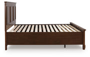 Ashley Furniture Danabrin Panel Storage Bed with sleek wooden panels and built-in storage drawers in a modern bedroom setting.