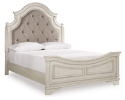 Ashley Furniture Realyn upholstered bed with a padded headboard in a neutral fabric, shown from a side angle.