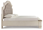Ashley Furniture Realyn upholstered bed with beige fabric, wooden frame, and side view showing headboard and mattress support.