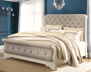 Ashley Furniture Realyn bedroom set with a large bed, dresser, and nightstands in a cozy, modern bedroom setting.