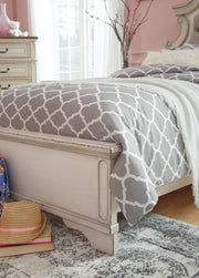 Close-up of the Ashley Furniture Realyn upholstered bed featuring soft fabric and detailed headboard design.