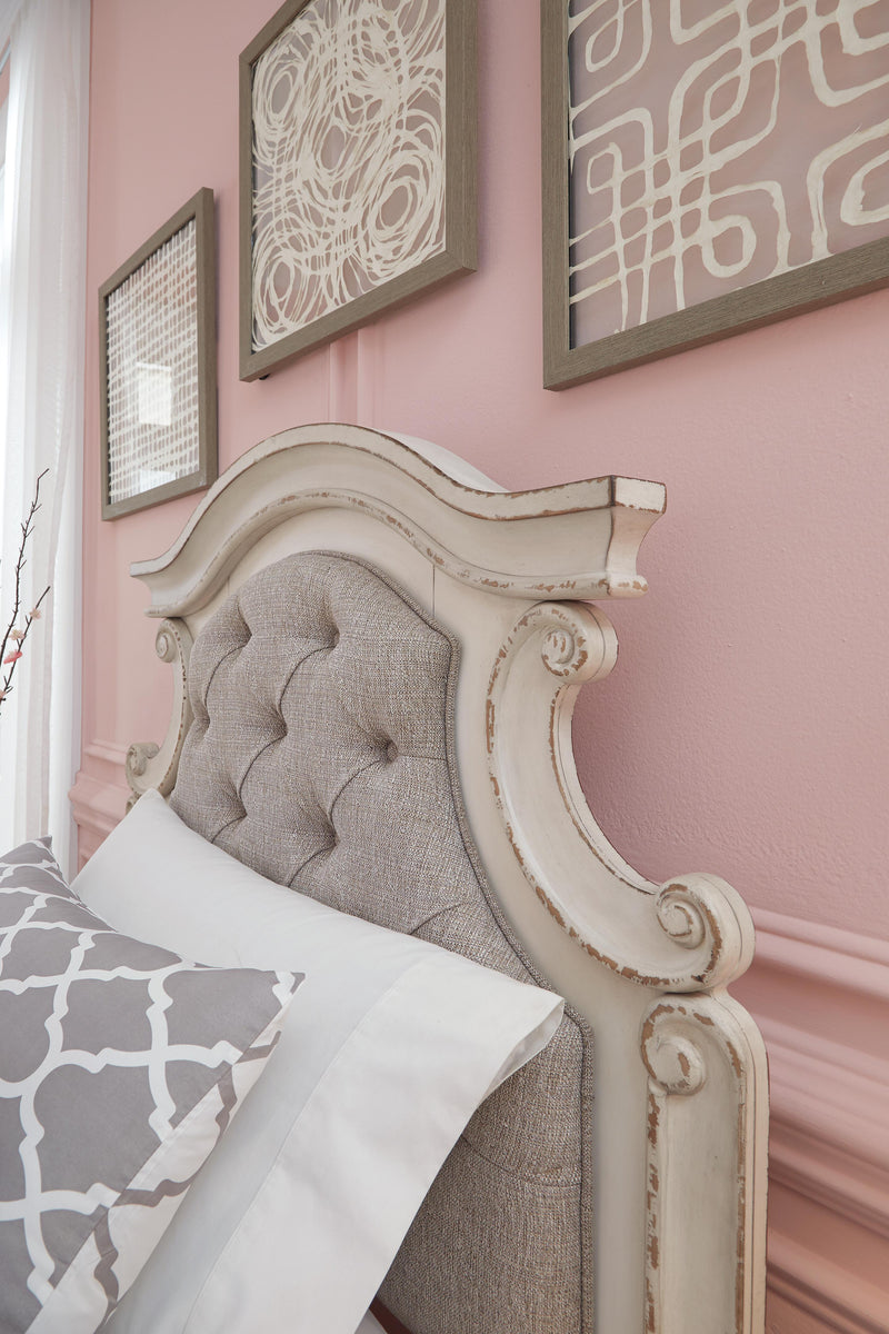 Ashley Furniture Realyn upholstered bed with padded headboard and fabric upholstery, showcasing a stylish bedroom centerpiece.