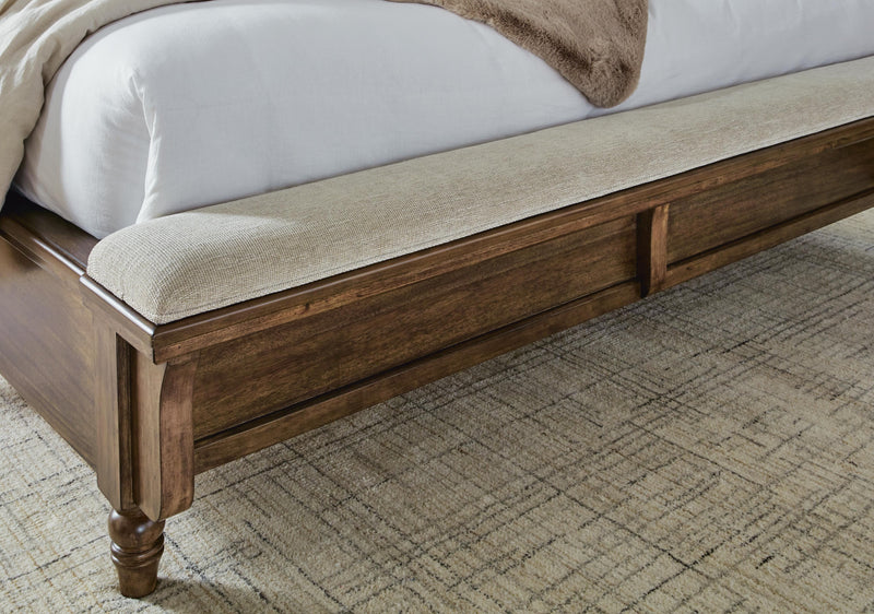 Ashley Furniture Sturlayne upholstered bed with a padded headboard and neutral fabric, showcasing a stylish bedroom centerpiece.