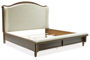 Ashley Furniture Sturlayne upholstered bed with a padded headboard and neutral fabric, shown from an angled side view.